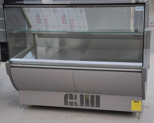 Gerades Glasfeinkostgeschäft zeigt Kühlschrank mit Stecker im Kompressor an